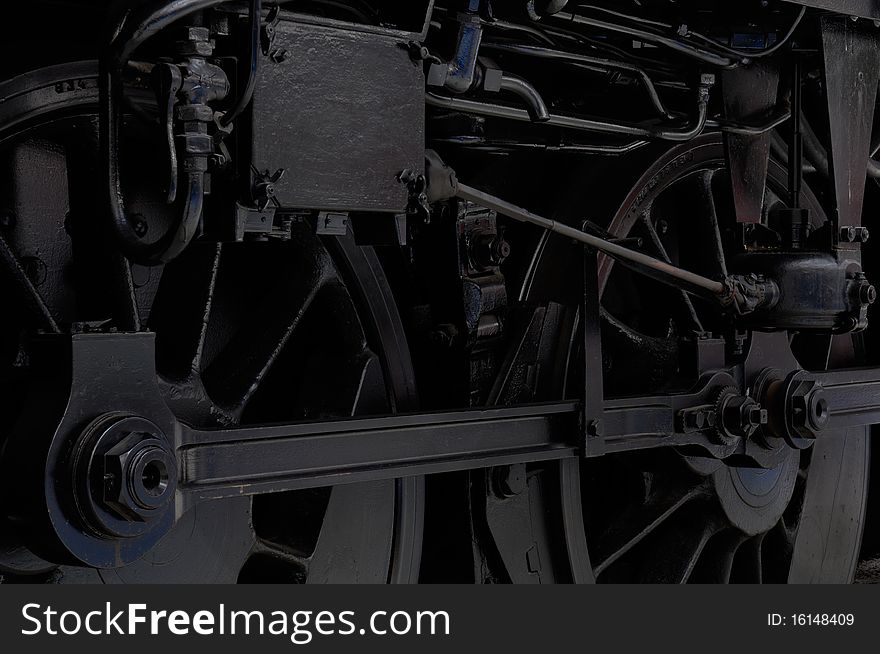 Lowkey shot of the wheels of a black vintage locomotive. Lowkey shot of the wheels of a black vintage locomotive