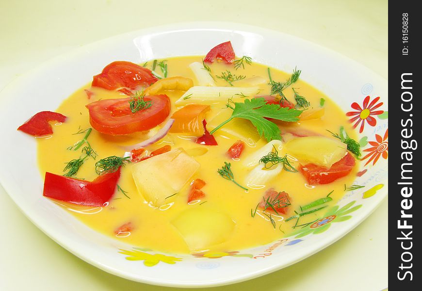 Yellow vegetable soup with tomato and pasta