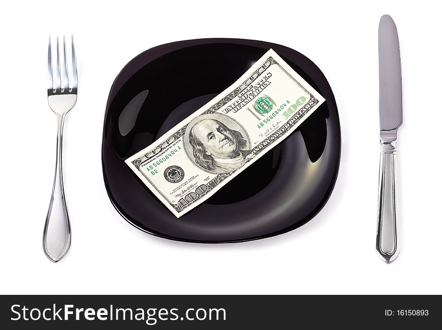 One hundred dollar banknote on a black plate with knife and fork