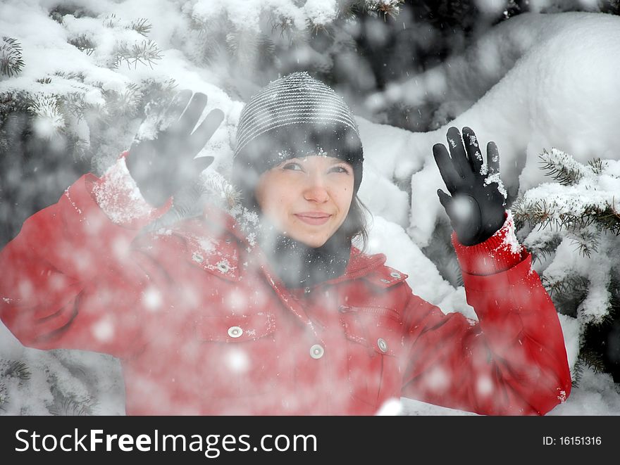 Snowfall is going while a girls is standing and watching it. Snowfall is going while a girls is standing and watching it