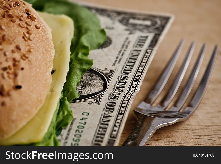 US dollars in a hamburger bun, close-up. US dollars in a hamburger bun, close-up