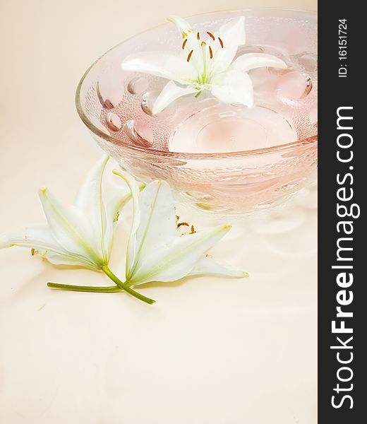 Spa bowl with pink water with lily flowers. Spa bowl with pink water with lily flowers