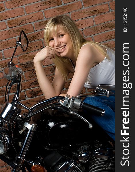 girl sitting on a motorcycle inside a studio with brick background. girl sitting on a motorcycle inside a studio with brick background