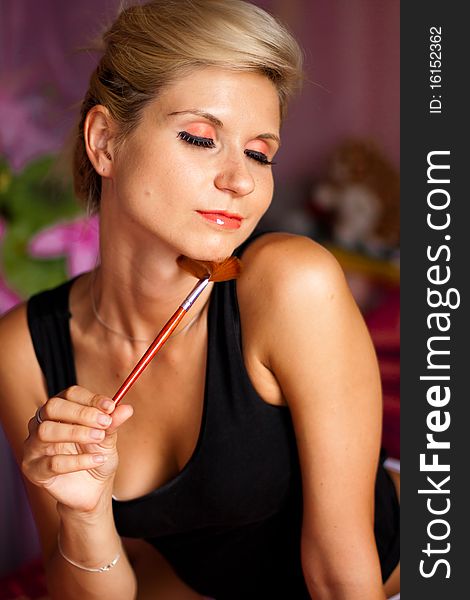 Beautiful girl holding a professional paintbrush for make-up. Beautiful girl holding a professional paintbrush for make-up