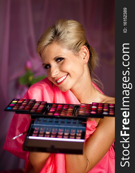 Beautiful girl holding a set of colored lipsticks for make-up. Beautiful girl holding a set of colored lipsticks for make-up