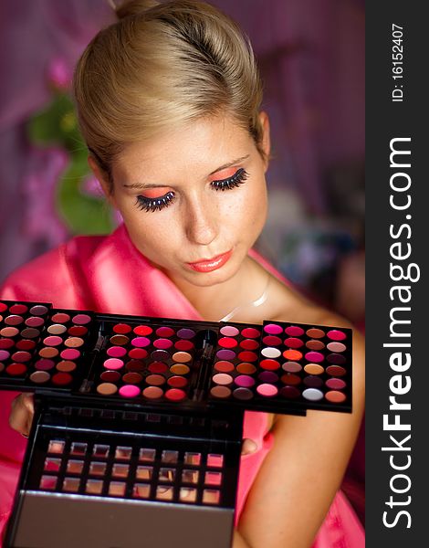 Beautiful girl with set of lipsticks for make-up
