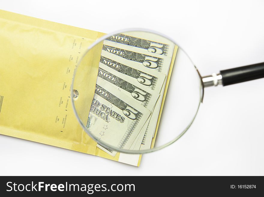 Dollars in the envelope with magnifying glass isolated on white background