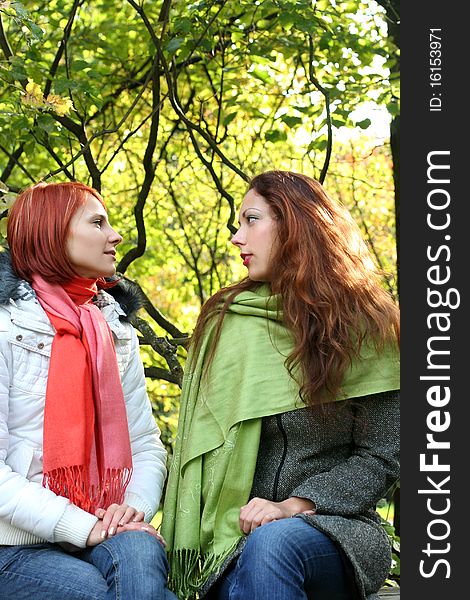 Two young girls relaxing in autumn park. Two young girls relaxing in autumn park