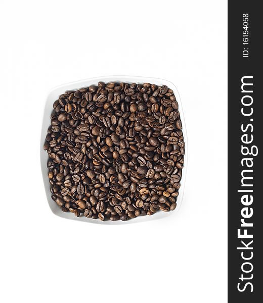 Dish of coffee seeds on white backdrop. Dish of coffee seeds on white backdrop