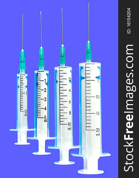 Four disposable syringe against blue background