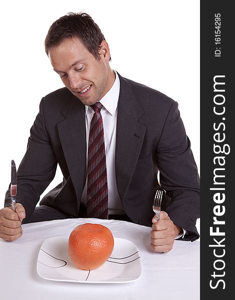 A man trying to be healthy and getting ready to dig into a orange on his plate. A man trying to be healthy and getting ready to dig into a orange on his plate.
