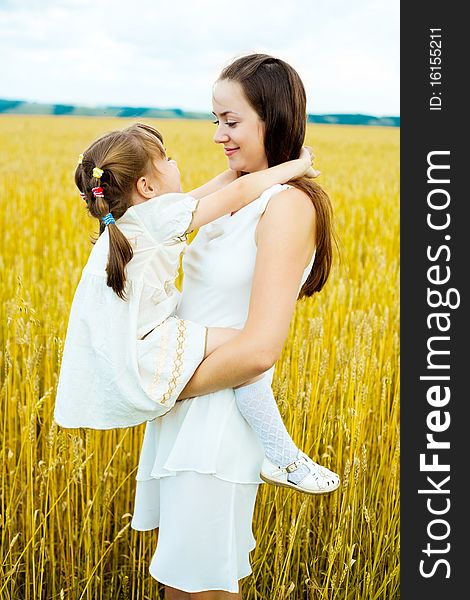 Beautiful young mother and her daughter having fun at the wheat field. Beautiful young mother and her daughter having fun at the wheat field