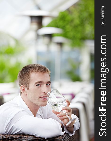 Young man drinking water at a restaurant