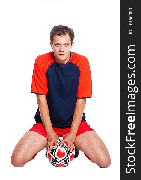 Football player in red clothes sitting in studio