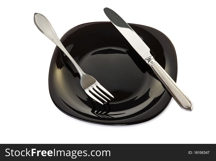 Black high-gloss plate with stainless fork and knife. Black high-gloss plate with stainless fork and knife