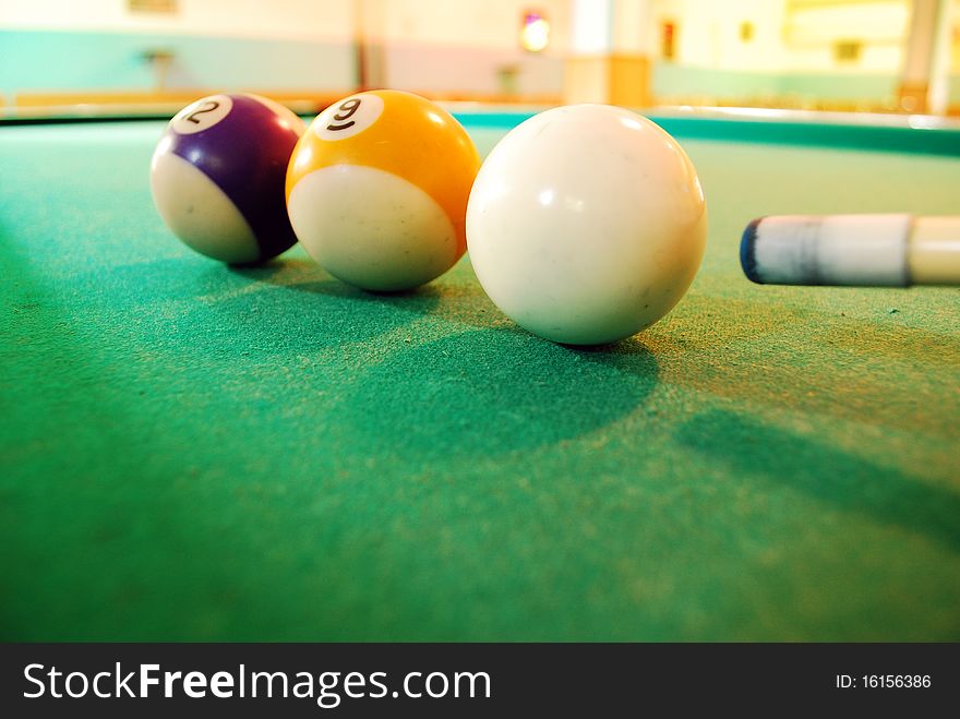 Closeup of a white Billiard Ball on green layout table with a stick ready to shot. Closeup of a white Billiard Ball on green layout table with a stick ready to shot