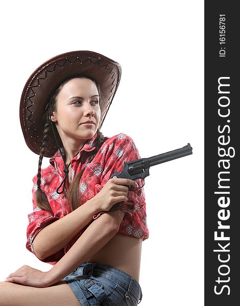 Pretty young girl in the cowboy hat with two pigtails arm with revolver. Pretty young girl in the cowboy hat with two pigtails arm with revolver