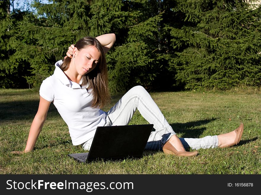 Smiling Girl With A Laptop On A Lawn