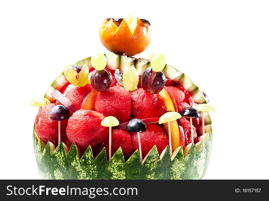 Watermelon rind filled with watermelon balls and grapes on white background. Watermelon rind filled with watermelon balls and grapes on white background.