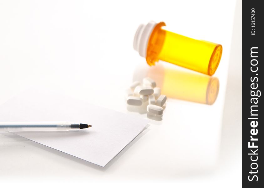 Medicine bottle, tipped over, pile of pills prescription and pen on a white background. Medicine bottle, tipped over, pile of pills prescription and pen on a white background.