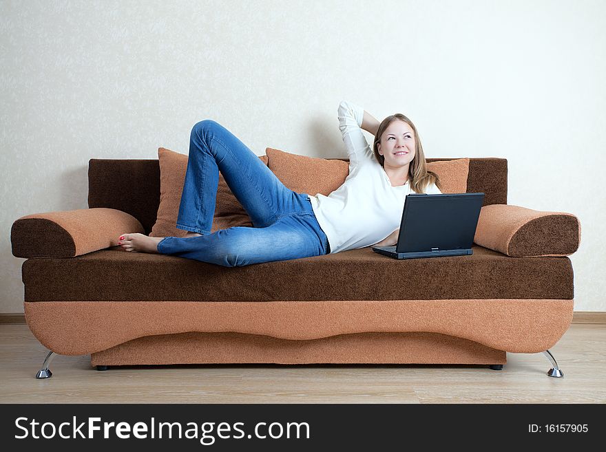 Young beatiful woman with laptop on the sofa