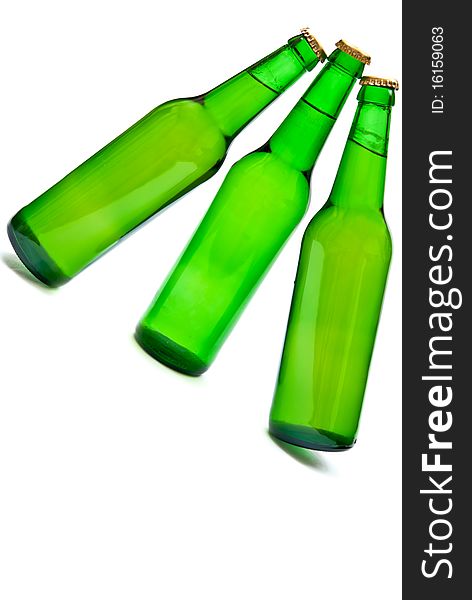 Three cold beers in green bottles isolated on white. Soft shadow. Three cold beers in green bottles isolated on white. Soft shadow