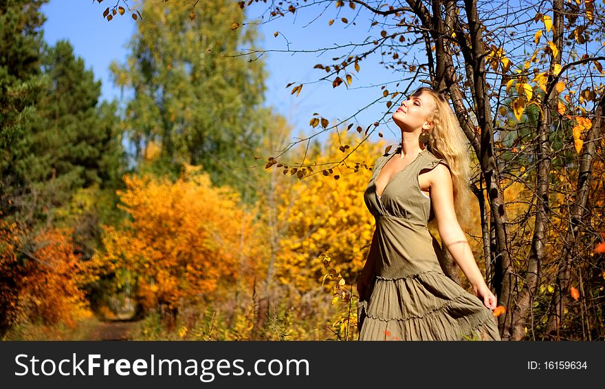 Attractive girl standing beside a tree
