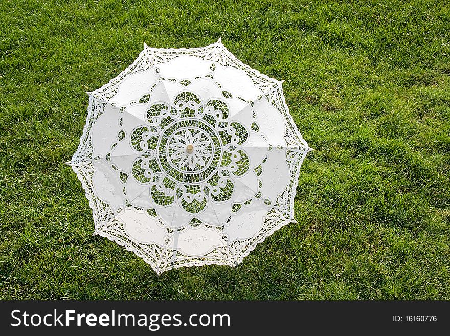 Beautiful white sun umbrella on the green lawn