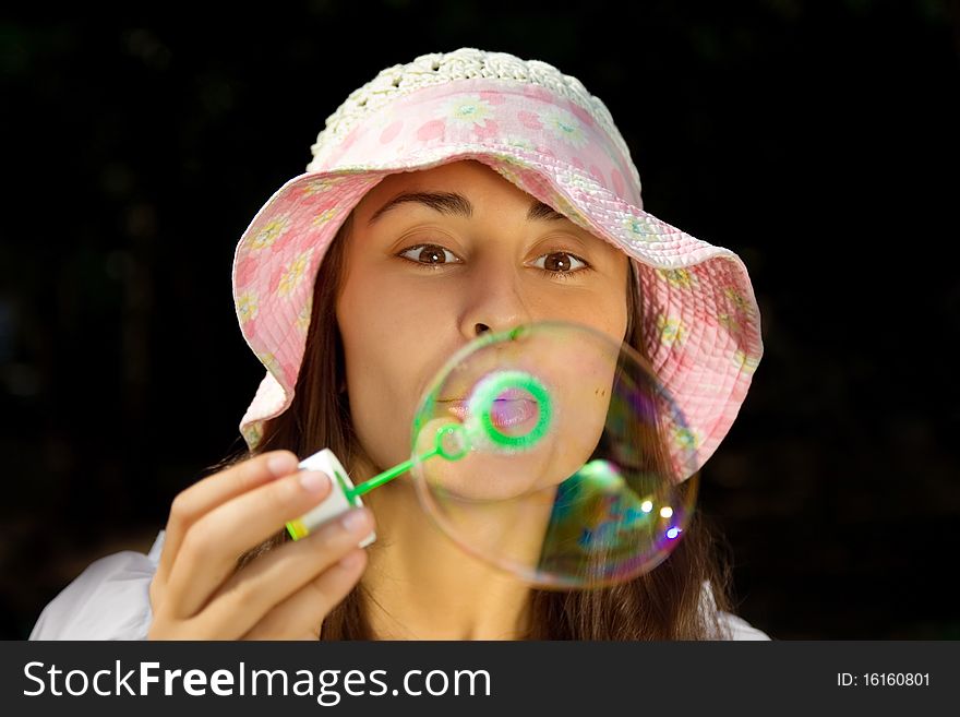 Portrait of a funny young girl blowing bubbles