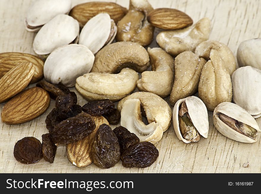 Mix of raisins, almond nut, cashew and pistachio on old wooden table