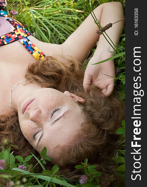 Beautiful Ginger Girl Is Lying In The Green Grass