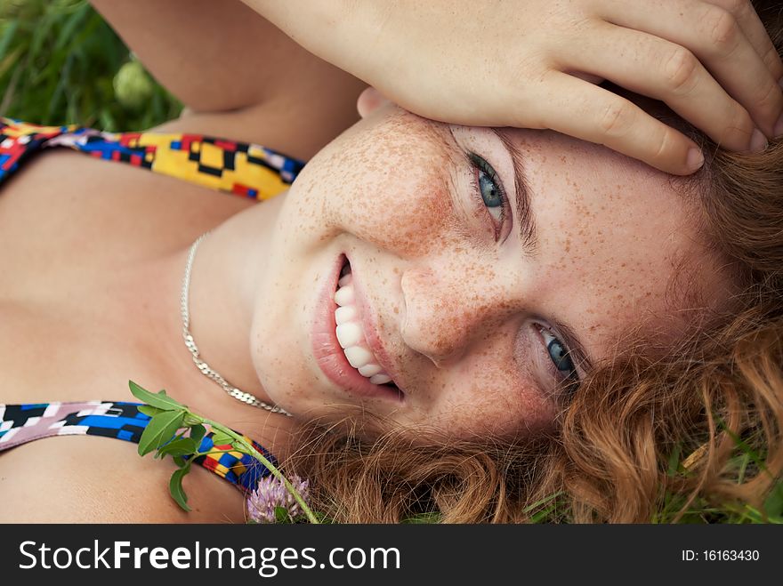 Beautiful Ginger Girl Is Lying In The Green Grass