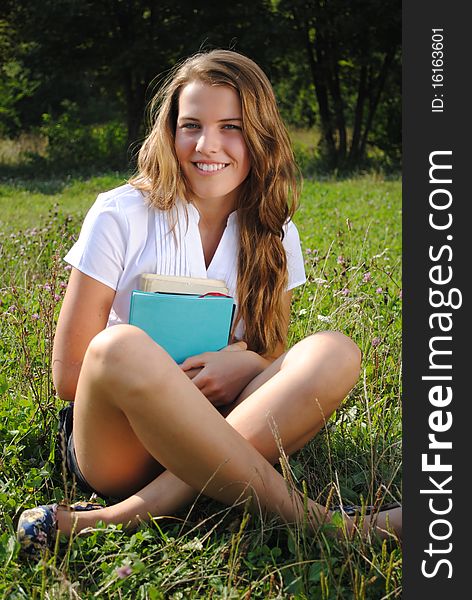 Beautiful Student Girl Is Seating With Books