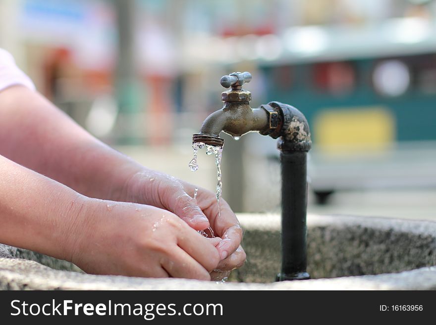 Woman washing hands on a public faucet. Woman washing hands on a public faucet