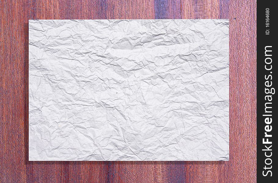 White crumpled paper on wood texture