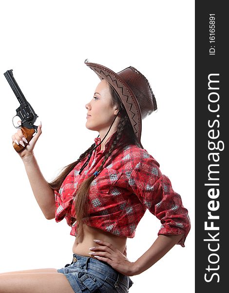 Pretty young girl in the cowboy hat with two pigtails with revolver. Pretty young girl in the cowboy hat with two pigtails with revolver