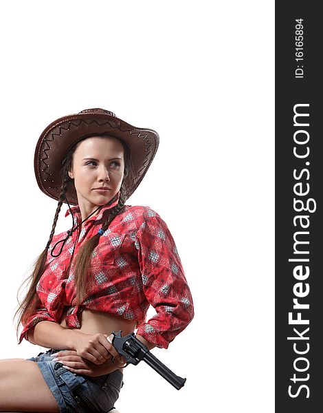 Pretty young girl in the cowboy hat with two pigtails with revolver. Pretty young girl in the cowboy hat with two pigtails with revolver