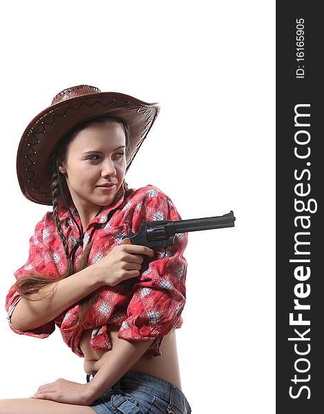 Pretty young girl in the cowboy hat with two pigtails with revolver aim. Pretty young girl in the cowboy hat with two pigtails with revolver aim