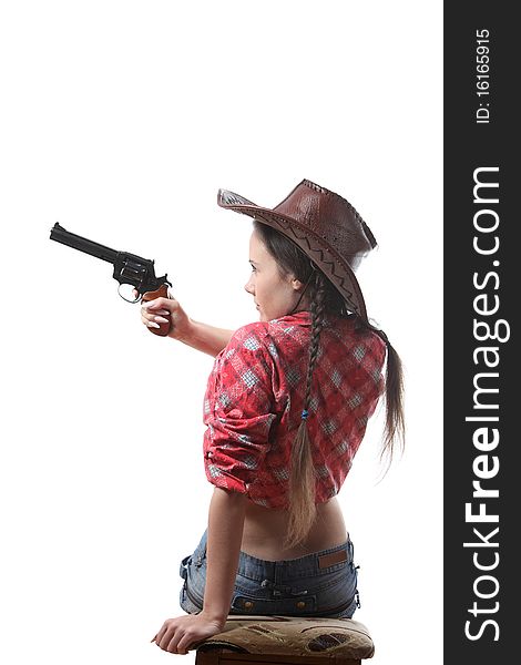 Pretty young girl in the cowboy hat with two pigtails with revolver aim. Pretty young girl in the cowboy hat with two pigtails with revolver aim