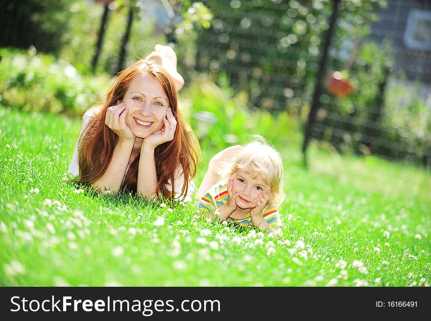 Beautiful young mother with her  daughter lie on grass . summer. Beautiful young mother with her  daughter lie on grass . summer.