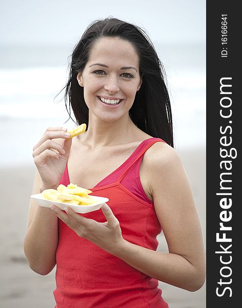 Woman eating chips at the beach
