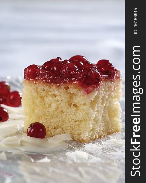 Piece of sponge cake topped with red currants