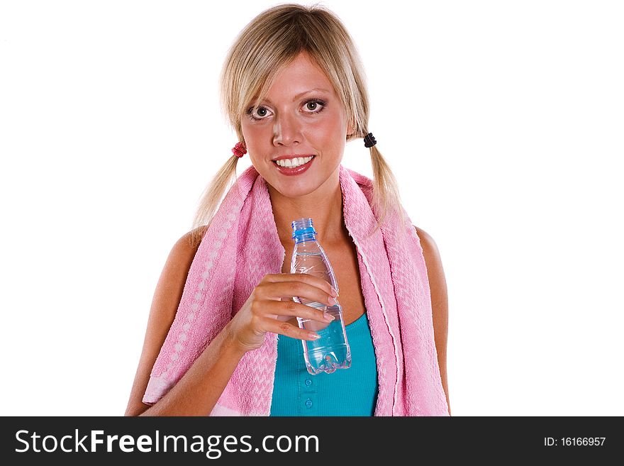 A girl holding water with a towel over her shoulder after a workout. Young woman drinking water and relaxing after a healthy workout. A girl holding water with a towel over her shoulder after a workout. Young woman drinking water and relaxing after a healthy workout.