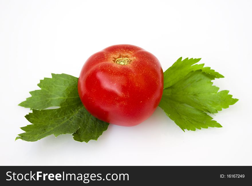 Red tomato on white background with two leaves.