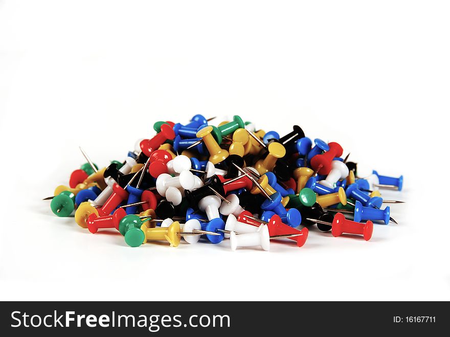 A pile of colourful thumbtacks isolated on a white background. A pile of colourful thumbtacks isolated on a white background