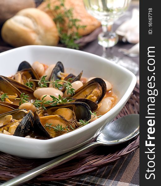 Mussel soup with bean and thyme on bowl