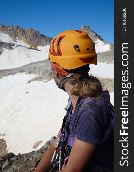 Hiker girl in orange helmet looking to far mountains