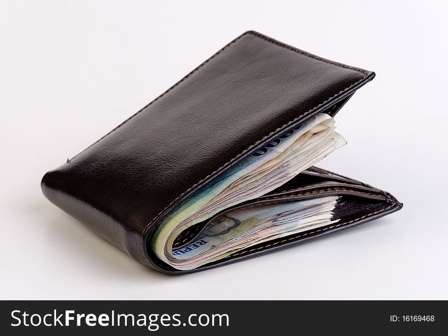 Wallet bulging with banknotes on a white background. Wallet bulging with banknotes on a white background