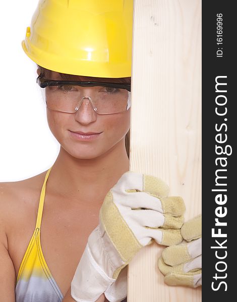 Female worker in bikini holding wood on white background