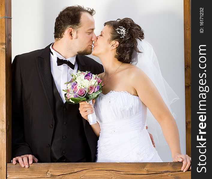 Bride and groom kissing with natural framing